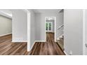 Hallway with wood-look floors leading to a staircase, a room and a patio with glass doors at 563 Navarre Dr, Stone Mountain, GA 30087