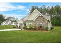 Attractive home with stone accents, green siding, and a well-maintained lawn on a sunny day at 100 Nemoura Ct, Fairburn, GA 30213