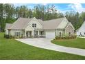 Inviting single-Gathering home with attached garage, stone accents, and beautiful landscaping at 100 Nemoura Ct, Fairburn, GA 30213