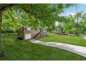 View of the brick home on a grassy lot with a long driveway and mature trees at 2015 Twelve Oaks Nw Cir, Kennesaw, GA 30144