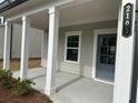 Inviting covered front porch with white columns and stylish front door at 2105 Boxwood Se Cir, Conyers, GA 30094