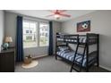 Bright bedroom with a bunk bed, a gray dresser, two windows, and a pink ceiling fan at 4011 Redan Rd # 9, Stone Mountain, GA 30083