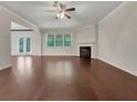 Open-concept living room with fireplace, hardwood floors, and abundant natural light from large windows and glass doors at 1477 Harlequin Way, Stockbridge, GA 30281