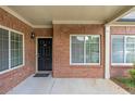 Inviting covered entryway with a classic black door, brick facade, and manicured landscaping at 2703 Brookhavenrun Cir, Duluth, GA 30097