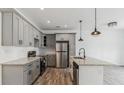 Modern kitchen with gray cabinets, stainless steel appliances, and a granite-topped island at 4011 Redan Rd # 10, Stone Mountain, GA 30083