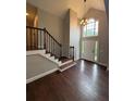 Bright foyer featuring hardwood floors, high ceilings, chandelier, staircase, and a large window above the front door at 7020 Walnut Mill Lndg, Cumming, GA 30040
