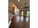 Open-concept living area with high ceilings, hardwood floors, large windows, and staircase at 7020 Walnut Mill Lndg, Cumming, GA 30040