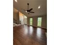 Spacious living room with hardwood floors, a ceiling fan, and a view of the front entrance at 7020 Walnut Mill Lndg, Cumming, GA 30040