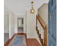 Inviting foyer featuring hardwood floors, staircase with wood railing, and a decorative pendant light at 4181 Singing Post Ne Ln, Roswell, GA 30075