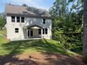 The home's backyard features a covered patio area and level lot with privacy provided by mature trees at 93 Riverwood Dr, Dallas, GA 30157