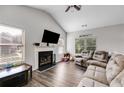 Cozy living room with fireplace, vaulted ceilings, wood floors, and large windows at 119 Sourwood Lane, Temple, GA 30179