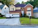Inviting two-story home with a manicured lawn, brick accents, and a two-car garage at 350 Rams Way, Tucker, GA 30084