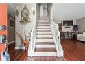 Inviting entryway with hardwood floors, staircase with white railing, and decorative accents at 5022 Audubon Pl, Norcross, GA 30093
