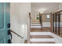 Inviting entryway showcasing hardwood steps, a staircase with metal accents, and views into the living spaces at 3343 Mooring Dr, Powder Springs, GA 30127