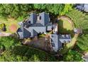 Aerial view of an estate home featuring manicured grounds, a private courtyard, and a stunning dark roof at 3863 Streamside Se Dr, Marietta, GA 30067