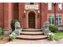 A grand front entrance with lion statues, flowers, and a striking wood door, welcoming you home at 3863 Streamside Se Dr, Marietta, GA 30067