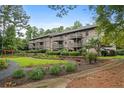 Condominium exterior featuring multiple balconies overlooking a landscaped lawn and garden area at 507 Embers Se Dr, Marietta, GA 30067