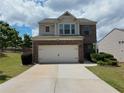 Two-story home with brick facade and attached two-car garage featuring a well-manicured lawn at 1369 Star Water Dr, Lawrenceville, GA 30045