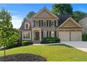 Charming two-story home boasts a landscaped yard, a two-car garage, and classic shutters at 4876 Sara Creek Way, Sugar Hill, GA 30518