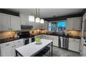 Bright kitchen features white cabinets, black countertops, stainless steel appliances, and center island with seating at 2132 Clairmont Rd, Brookhaven, GA 30033