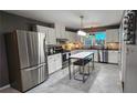 Open kitchen with stainless steel appliances, white cabinets, center island, and great natural light at 2132 Clairmont Rd, Brookhaven, GA 30033