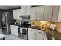 Kitchen with stainless steel appliances, white cabinets, dark countertops, and open layout at 2132 Clairmont Rd, Brookhaven, GA 30033
