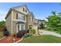 Lovely home featuring stone accents, lush landscaping, and a well-maintained lawn at 4195 Settlers Grove Rd, Cumming, GA 30028
