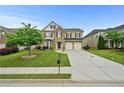 Beautiful two-story home featuring a well-manicured lawn, stone accents, and a two-car garage at 4195 Settlers Grove Rd, Cumming, GA 30028