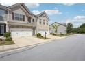 Exterior view of a home showcasing its two-car garage and well-manicured landscaping at 5527 Fairhaven Pl, Fairburn, GA 30213