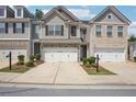 Charming townhome featuring a two-car garage and professionally landscaped front yard at 5527 Fairhaven Pl, Fairburn, GA 30213