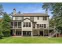 Large back exterior features a patio, screened in porch and large grassy yard at 4823 Layfield Dr, Dunwoody, GA 30338