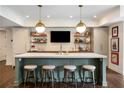 Finished basement bar area with marble countertop, pendant lighting, and sports-themed decor at 4823 Layfield Dr, Dunwoody, GA 30338