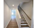 Hallway with wood-look floors and a staircase with wooden handrail at 670 Redhead Way (Lot 23), Grayson, GA 30017