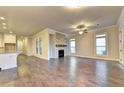 Open-concept living room featuring hardwood floors, natural light, and fireplace with view into the kitchen at 520 Pearl St, Cumming, GA 30040