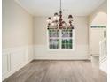 Inviting dining room with modern lighting, wainscoting, and wood-look floors at 602 Jules Crest Ct, Lawrenceville, GA 30045
