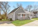 Side view of a cute gray home with a front porch and driveway at 1091 Longley Nw Ave, Atlanta, GA 30318