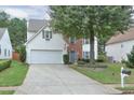 Inviting two-story home features a two-car garage, brick facade, and mature trees in a well-manicured front yard at 3060 Baymount Dr, Lawrenceville, GA 30043