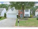 Charming two-story home with a manicured lawn, mature tree, and a convenient two-car garage at 3060 Baymount Dr, Lawrenceville, GA 30043