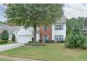 Traditional two-story home with a spacious front lawn, mature shade tree, and a two-car garage at 3060 Baymount Dr, Lawrenceville, GA 30043