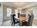Dining room with a wooden table, gray chairs, pendant lighting, and neutral decor at 1109 Georgian Point Dr, Lawrenceville, GA 30045