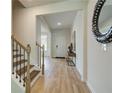 Light-filled foyer with wood-look floors, staircase, and stylish decorative mirror at 1109 Georgian Point Dr, Lawrenceville, GA 30045