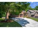 Long driveway leading to a brick home with a three-car garage and well-maintained landscaping at 1185 Gallatin Way, Suwanee, GA 30024