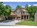 Beautiful brick home with a three-car garage, arched entryway, and lush green lawn at 1185 Gallatin Way, Suwanee, GA 30024