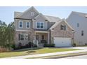 A two-story home showcasing a blend of gray siding and brickwork with a neatly manicured lawn at 211 Aspen Valley Ln, Dallas, GA 30157