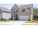 Well-kept lawn and a two-story brick and gray home featuring a front-facing two car garage at 211 Aspen Valley Ln, Dallas, GA 30157