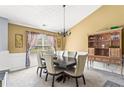 Elegant dining room with stylish furniture, decorative light fixture, and sunlit window at 995 Chimney Trace Way, Lawrenceville, GA 30045