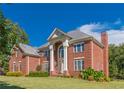 Side view of a two-story brick house featuring a well-maintained lawn and lush landscaping with multiple windows at 270 Annelise Park Dr, Fayetteville, GA 30214