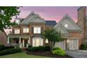 Charming brick home boasts a well-kept lawn, covered porch, and convenient two-car garage under a lovely twilight sky at 3250 Seven Oaks Dr, Cumming, GA 30041