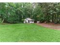 Expansive front yard view featuring a cozy home with a well-manicured lawn, set among mature trees at 2865 Chattahoochee Rd, Cumming, GA 30041