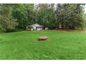 Spacious front lawn leading to a quaint home nestled among trees, offering a serene and private setting at 2865 Chattahoochee Rd, Cumming, GA 30041
